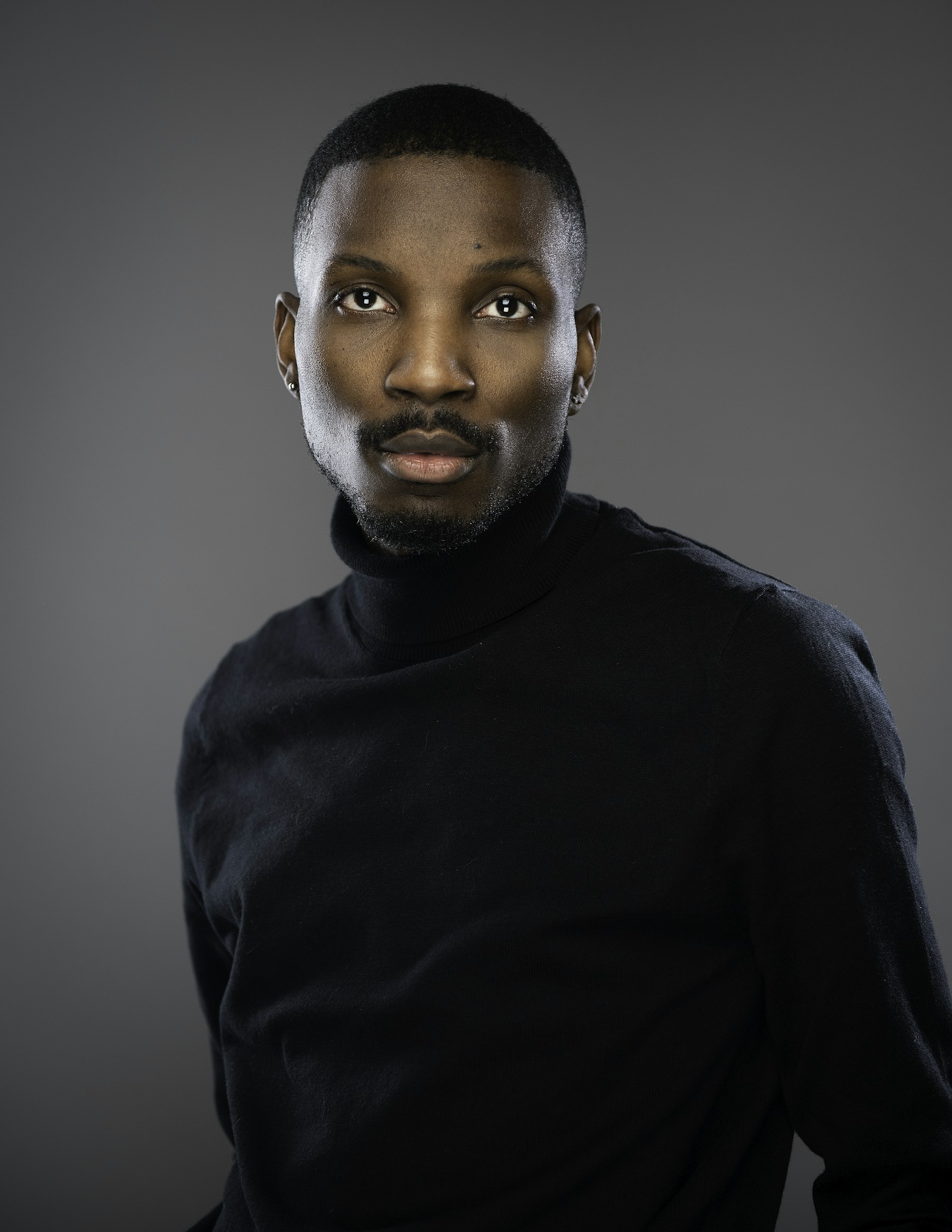 Daniel Okorie, studio portrait in a black roll-neck